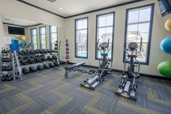 A gym with a variety of equipment including weights and exercise machines.